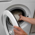 high-angle-adult-loading-washing-machine_23-2149535091
